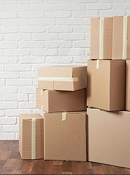 A stack of boxes in front of a brick wall.